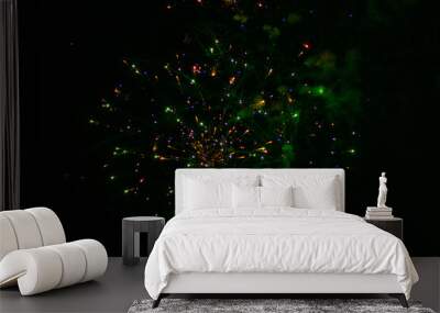 Beautiful fireworks, splashes of yellow and green colors, with a slight haze of green, in the night sky Wall mural