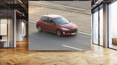 Passenger car red in the city Wall mural