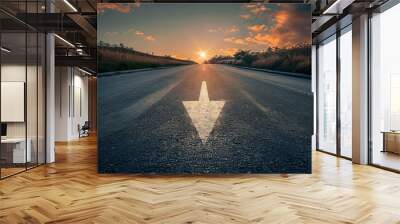 Close-up of a road arrow pointing forward, leading towards a glowing sunset through a tree-lined path in golden light.. Beautiful simple AI generated image Wall mural