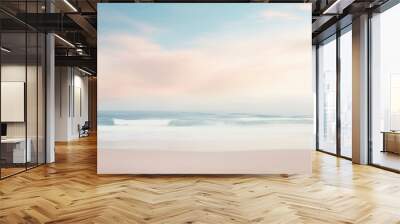 A beach with a pastel colored sky and the ocean in the background. Wall mural