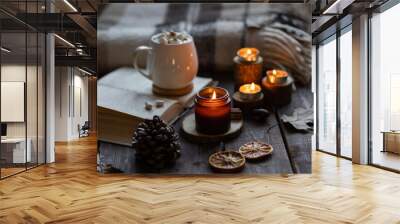 Aromatherapy on a grey fall morning, atmosphere of cosiness and relax. Autumn cozy home composition with hot chocolate with marshmallow and candles. Wooden background, books, close up. Wall mural