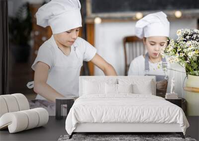 Brother and sister baking homemade sweet pie together, having fun. Home bakery, little kids in process of food preparation in the kitchen at home, helping mother, doing chores Wall mural