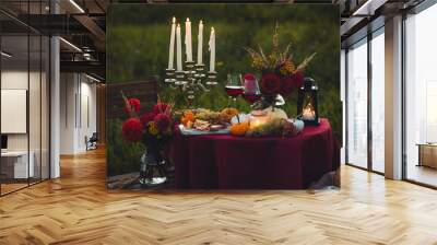 Fall mood, romantic date outdoors in the garden, candlelight dinner for a couple. Private wedding for two. Pumpkin countryside decor, red dahlia, cheese plate, grapes. Gourmet food, elegant setting Wall mural