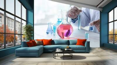 Young man scientist in glasses and gloves working on laboratory test of blue liquid in tube, chemistry science, medical biology experiment technology, pharmacy development solution. Close up Wall mural