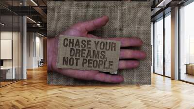 Conceptual hand writing showing Chase Your Dreams, Not People. Business photo text Do not follow others chasing goals objectives Cardboard with marked some letters on human hand jute sack ground Wall mural