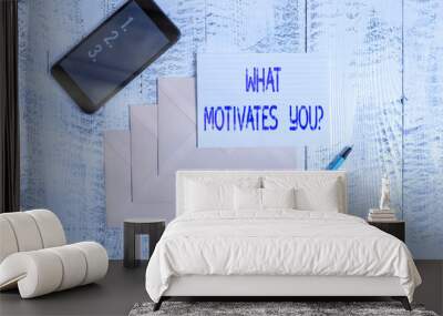 Conceptual hand writing showing What Motivates Youquestion. Concept meaning know reasons why you want to wake up each morning Envelopes marker ruled paper smartphone wooden background Wall mural