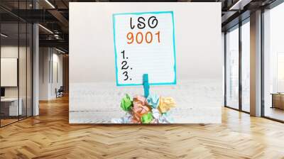 Handwriting text Iso 9001. Conceptual photo designed help organizations to ensure meet the needs of customers Reminder pile colored crumpled paper clothespin reminder white wooden space Wall mural