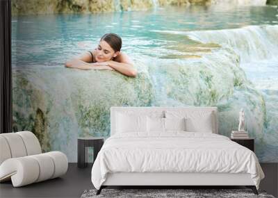 Young woman lying in the natural thermal pool, Saturnia, Italy Wall mural