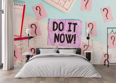 Text sign showing Do It Now. Business photo showcasing not hesitate and start working or doing stuff right away Writing tools, computer stuff and math book sheet on top of wooden table Wall mural