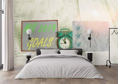 Text sign showing My 2019 Goals. Business photo text setting up demonstratingal goals or plans for the current year Mini blue alarm clock standing above buffer wire between two notation paper Wall mural