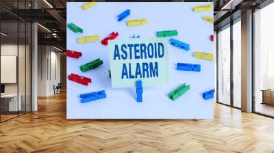 Word writing text Asteroid Alarm. Business photo showcasing warning to prepare the cities in a space rock flight path Colored clothespin papers empty reminder white floor background office Wall mural