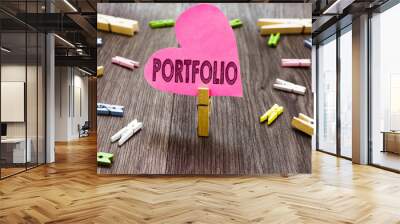 Writing note showing Portfolio. Business photo showcasing Examples of work used to apply for a job Combination of shares Clothespin holding pink paper heart several clothespins wooden floor Wall mural