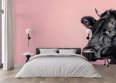 Black cow head on pink background looking to side Wall mural