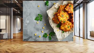 Crispy corn fritters on parchment with parsley garnish gray background Wall mural