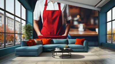 Elegant barista in white shirt and red apron stands ready in a cozy, well-lit cafe, with mugs and a rustic ambiance Wall mural