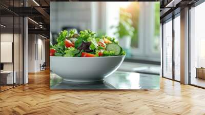 Fresh mixed salad in white bowl on kitchen counter with natural light Wall mural