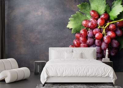 Fresh red grapes with green leaves on textured gray background Wall mural