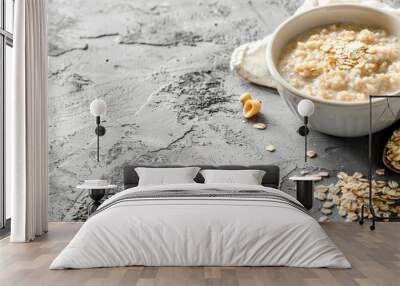 Oatmeal in bowl on textured surface with scattered oats Wall mural