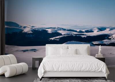 Panoramic view over the ski slope Poiana Brasov ski resort in Transylvania, Pine forest covered in snow on winter season,Mountain landscape in winter with the Bucegi Mountains in the background. Wall mural