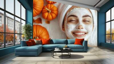 Smiling woman with facial mask surrounded by pumpkins Wall mural