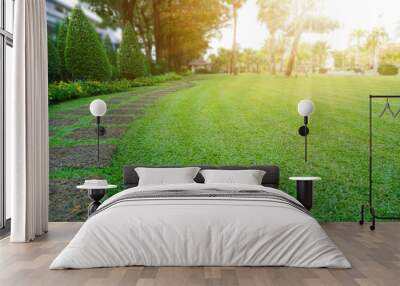 Pattern of Laterite steping stone on a green Lawn in the public park, Ficus and shurb on the left , Trees in background under evening sunlight Wall mural