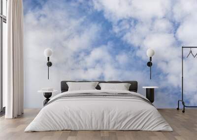 Upward view of white fluffy clouds on vivid blue sky Wall mural