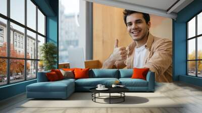 Indian man using laptop computer, showing thumb up, looking at camera and smiling, working from home. Happy asian student studying, learning language, watching online training courses Wall mural