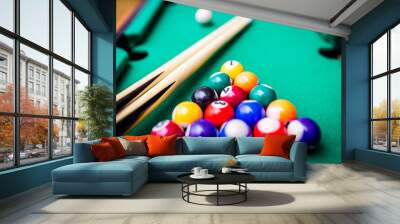 Billiard cues and pyramid of multicolored snooker pool balls on green billiard table. Wall mural