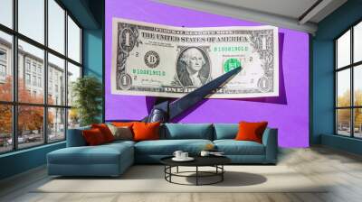 Financial concept.scissors cut money on purple background.Concept of spending money,scissors cut money of USA. Wall mural