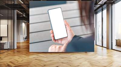 Mockup image blank white screen cell phone of woman's hand holding using mobile phone at cafe.copy space,blank screen for text.concept for business,people communication,technology electronic device. Wall mural