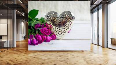 Valentine's Day greeting card. A bouquet of red roses and a beautiful shiny metal heart on a white table, copy space. Wall mural