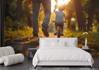 A man helps his son learn to ride a bicycle Wall mural