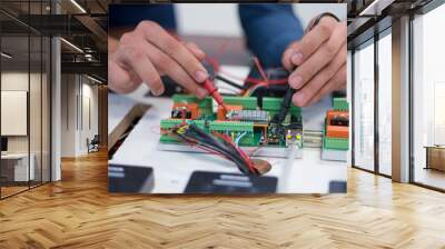 two young handsome engineers working on electronics components.tech tests electronic equipment in se Wall mural