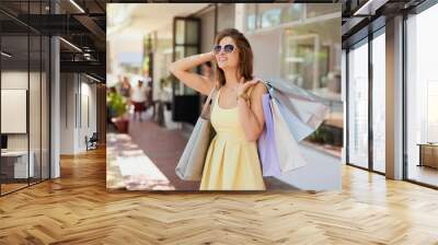 Woman, city and retail fashion for shopping bags, confident and happy customer for designer clothes. Female person, purchase and downtown buyer in sunglasses, boutique deal and present in outdoor Wall mural