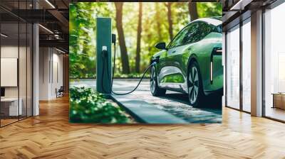 A modern electric vehicle charging at a station amidst a lush green forest environment Wall mural