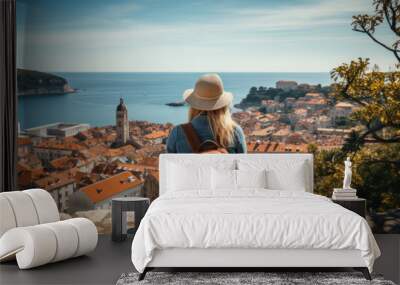 A young woman with a backpack looks at the city of Dubrovnik, Croatia. Wall mural