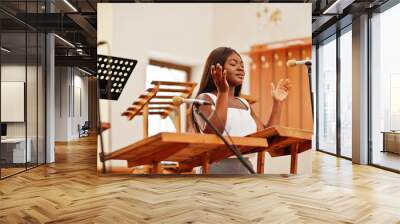 African american woman praying in the church. Believers meditates in the cathedral and spiritual time of prayer. Afro girl singing and glorifying God on choruses. Wall mural