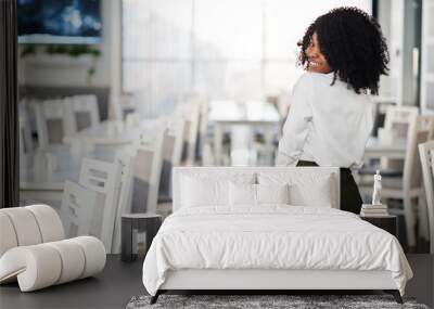 Back of cheerful sexy business african american lady with afro hair, wear white blouse and green pants posed in cafe. Wall mural