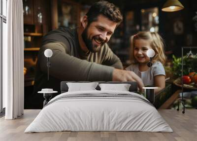 Cute little girl helping her father to prepare salad in the kitchen. Wall mural