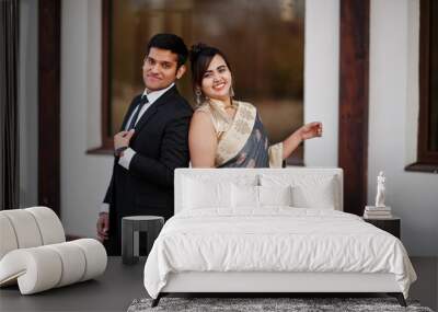 Elegant and fashionable indian friends couple of woman in saree and man in suit. Wall mural