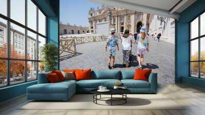 Family walking near St. Peter's Basilica church in Vatican city. Wall mural