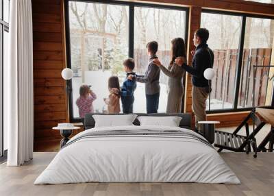 Family with four kids in modern wooden house against large window. Wall mural