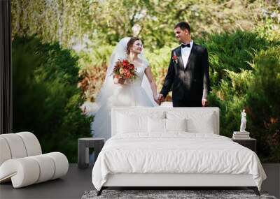 Fantastic wedding couple enjoying each other's company in the park. Wall mural