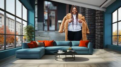 Glamorous african american woman in warm fur coat pose at street. Wall mural