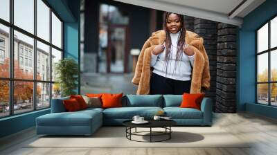 Glamorous african american woman in warm fur coat pose at street. Wall mural