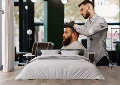 Handsome bearded man at the barbershop, barber at work. Wall mural