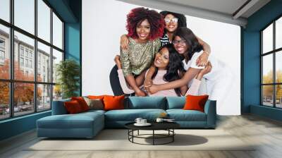 Happy brightful positive moments of four african girls. Having fun and smiling on chair against white empty wall. Lovely moments of four hugging best friends. Wall mural