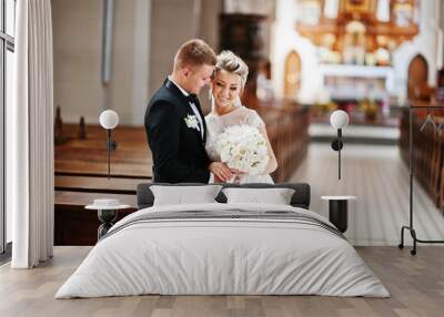 Photosession of stylish wedding couple on catholic church. Wall mural