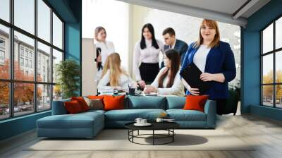 Portrait of caucasian woman against business people group of bank workers have meeting and working in modern office. Wall mural