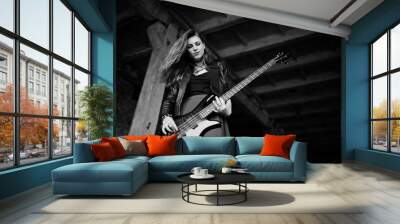 Red haired punk girl wear on black and red skirt, with bass guitar at abadoned place. Portrait of gothic woman musician. Wall mural